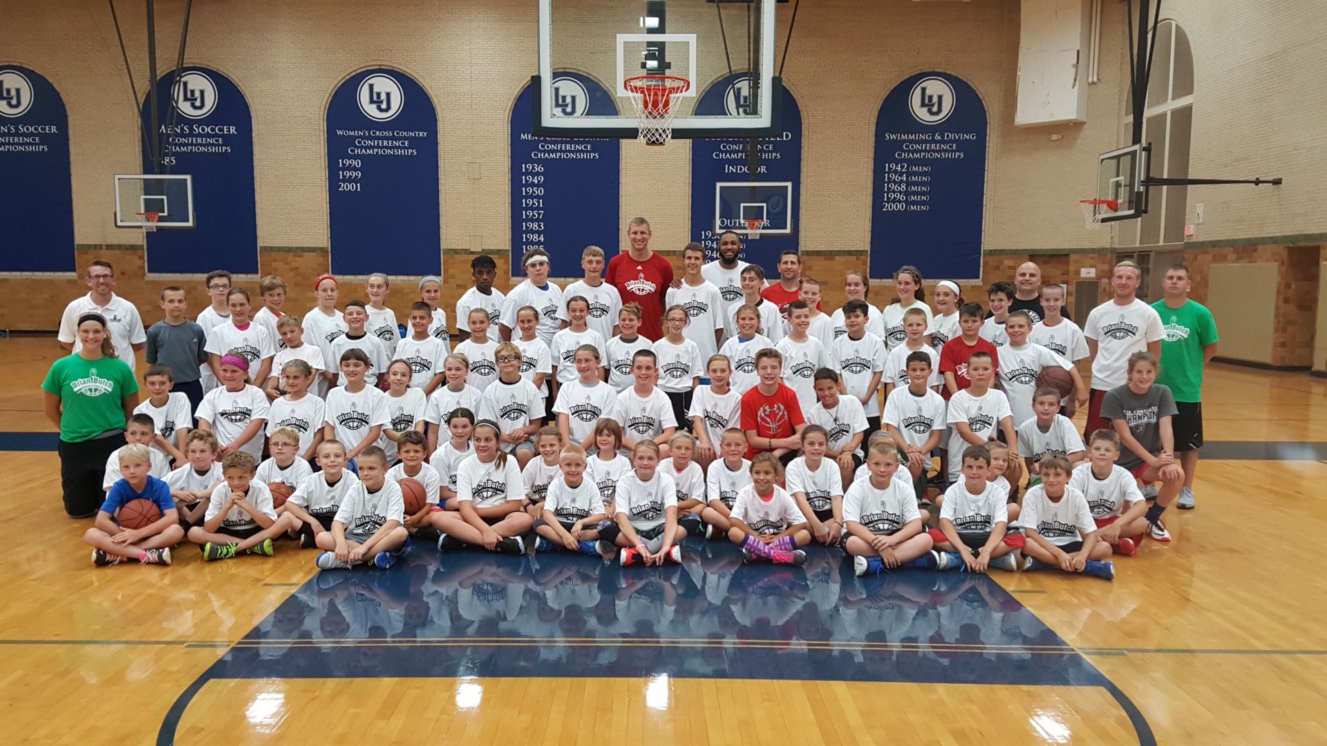 Butch (top row, center, in red) and a group of campers from a previous Brian Butch Basketball Camp