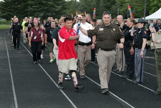 Portage County Sheriff’s Office’s Deputy Travis Levandowski of the carries the torch with athlete Zachary Reetz