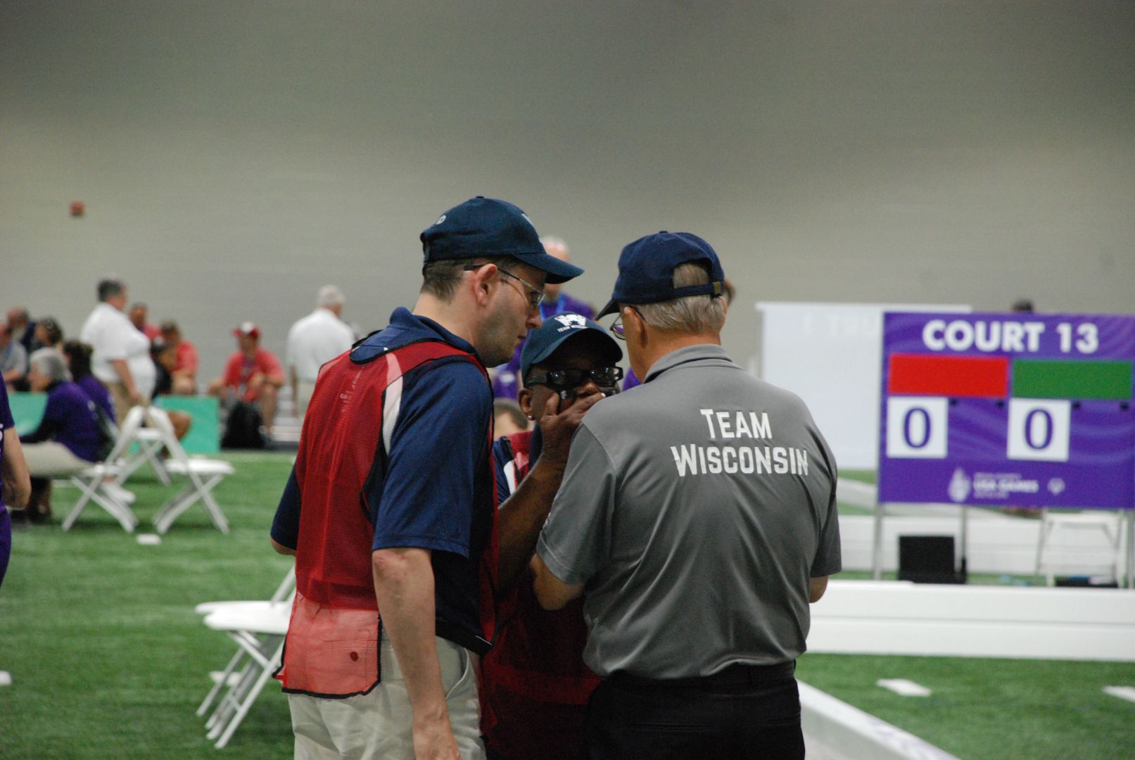 Jonathan Frank and Cindy Bentley talk strategy with Coach John Haberle during Tuesday's doubles pool play
