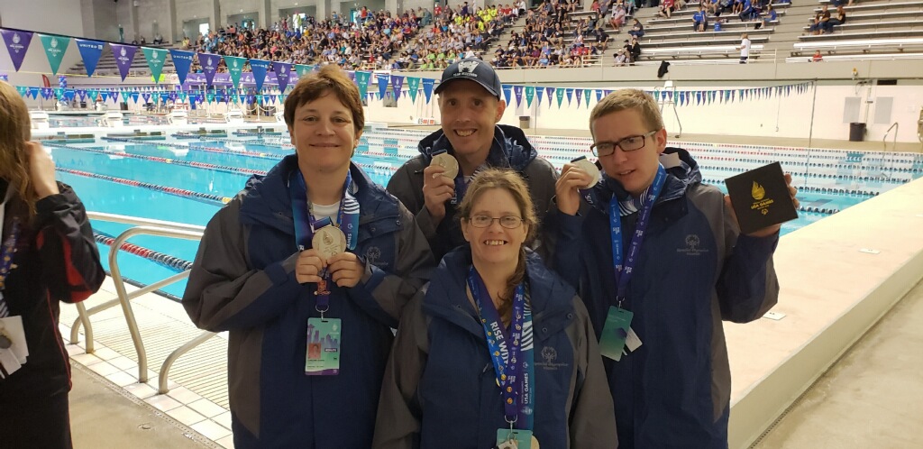 Seth Rehrauer (R) shows off his new hardware with his teammates Christine Cherne, Steve Woodard and Cindy Dexter (L to R)