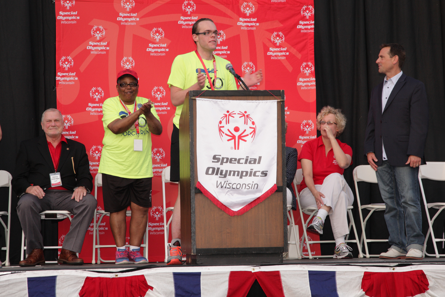 Thompson (at podium) is joined by Hill (right) and Cindy Bentley in honoring Alldridge at the 2016 Summer Games