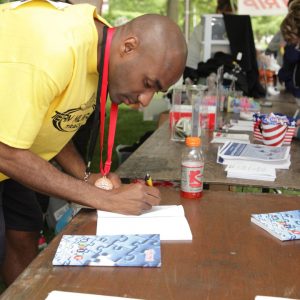 Garner signing his book after his stirring speech at the Opening Ceremony of the 2018 State Summer Games