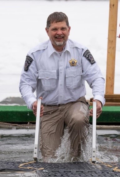 Man in police uniform emerges from icy waters