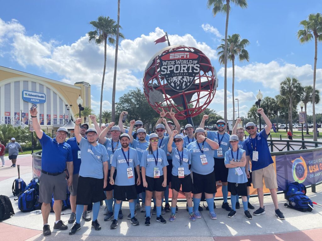 Athlete as Coach Travis Stuckart poses with Team Wisconsin softball outside ESPN Wide World of Sports globe in Orlando.