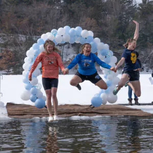 three women leap from ice into lake