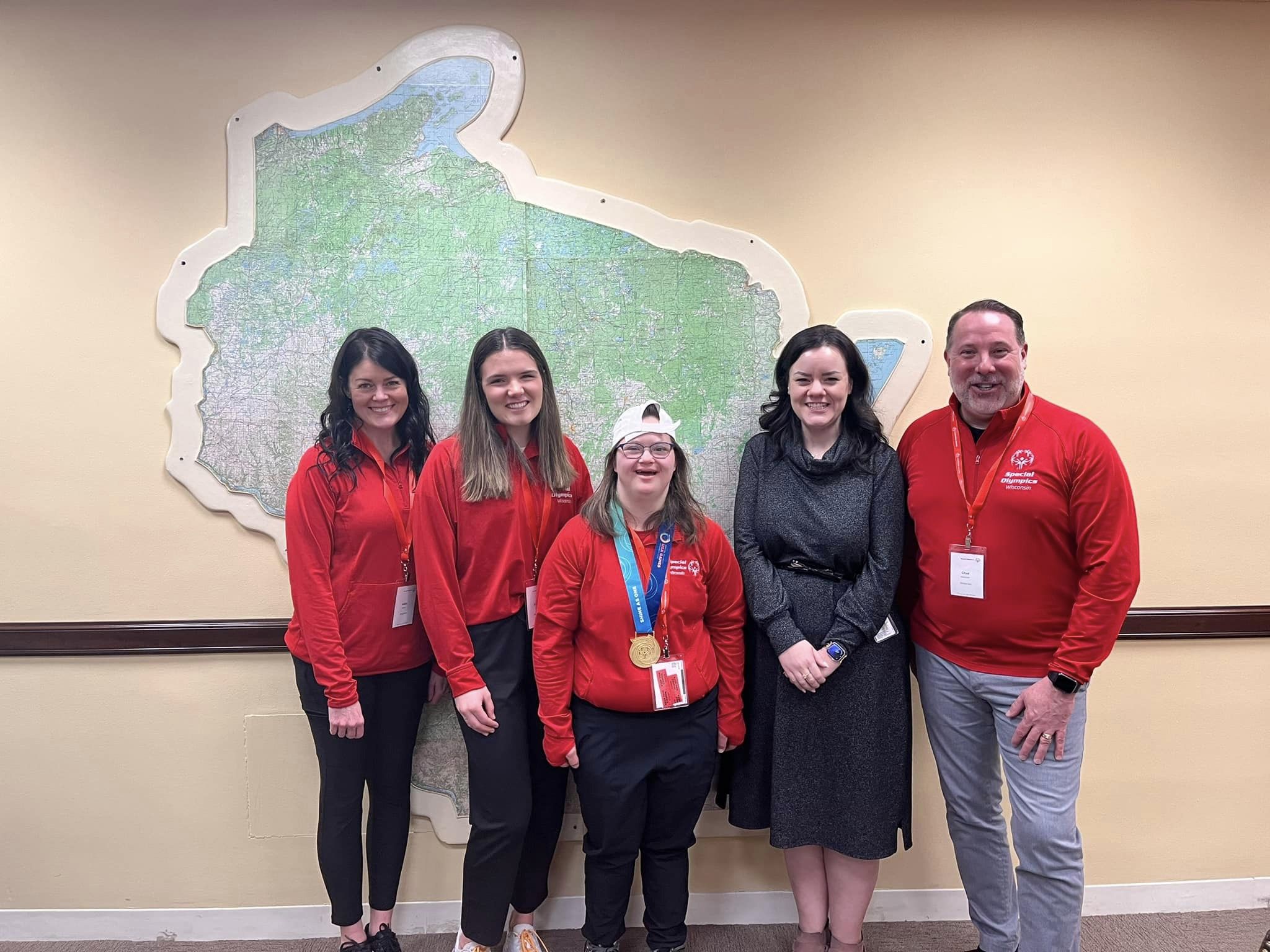 Annie, group stands in front of Wisconsin map